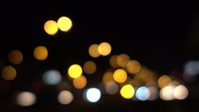 Out of focus background with moving bokeh circles of night traffic and car light,  plate of city street from road at night. Blurry Video backdrop in urban area as transportation and traffic concept. 4K