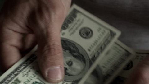 Close-up - Men's Hands Counting Out Dollar Bills. Concept Of Salary And Financial Instability During A Crisis