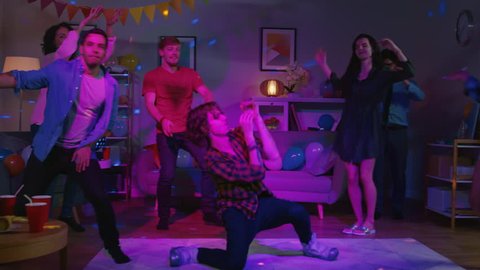 At the College House Party: Diverse Group of Friends Have Fun, Dancing and Socializing. One Guy Does Modern Dance Moves, Girls Cheer. Boys and Girls Dance in the Circle. Disco Neon Strobe Lights.