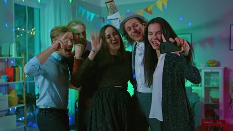 Happy Group of Young People Taking Collective Selfie at the Wild House Party. Neon Lights, Disco Ball and Funny Costumes.