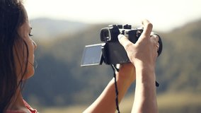 A young woman shoots the nature of the mountain Altai on her camera