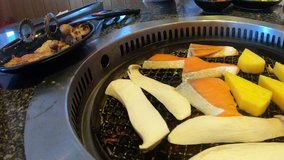 Action camera take video clip close up food with Salmon on a charcoal stove Grilled salmon with mushrooms and Japanese eggs in restaurant. For delicious image