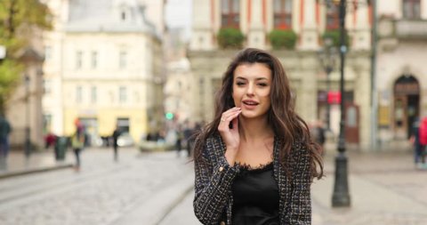 4k. Business woman walks across the old town. Young and strong. Old European architecture