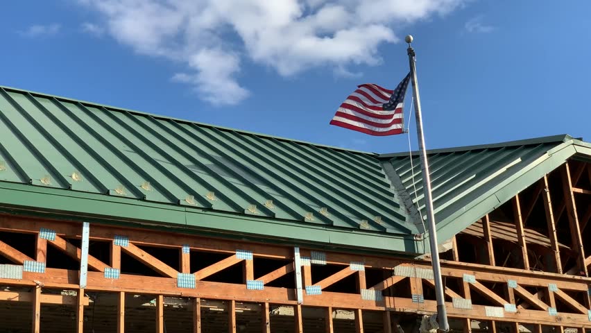 USA Flag on top of the building that lost facade after strong winds 