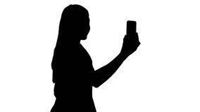 Silhouette Female in pink dress making video call with her smart phone.