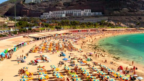Aerial view of the famous Amadores beach and seafront with palm trees and people lying on the beach. Spanish resort. Gran Canaria, Canary islands, Spain