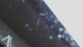 Heavy raining in tropical country water from roof dropping down ,low angle view.
Raindrops from  roof with bokeh ,HD video.