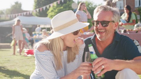 Slow Motion Portrait Of Mature Couple At Summer Garden Fete Celebrating With Drinks