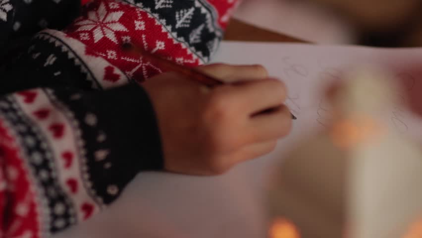 Close-up of writing a letter to Santa by little girl in slowmo