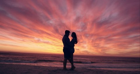 Happy couple kissing on beach at sunset silhouette in love dating on honeymoon RED DRAGON Video Stok
