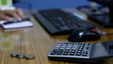 office worker doing accounting with calculator on desk. Selective focus