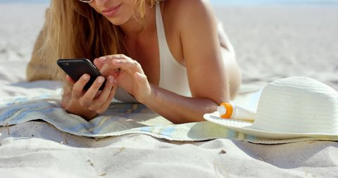 beautiful woman using phone text messaging conversation lying on beach suntanning RED EPIC DRAGON