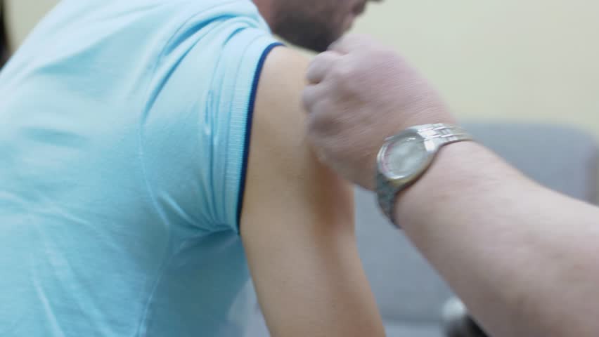 Doctor makes vaccination in the man's hand. Injection of a syringe in the shoulder close-up. 4k | Shutterstock HD Video #1020510736
