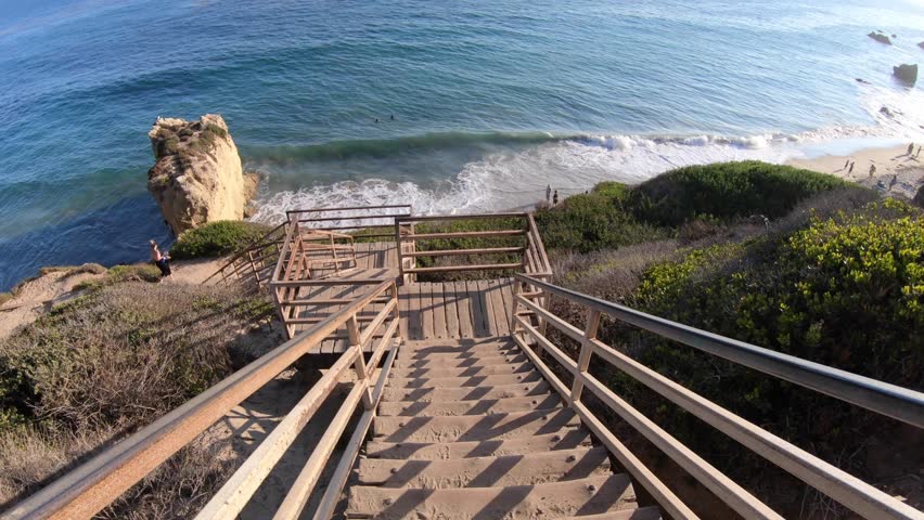 Scenic wooden stairway leading down to El Matador State Beach at sunlight. Pacific coast, California, United States. Pillars and rock formations of most photographed Malibu beach, popular spot shot.