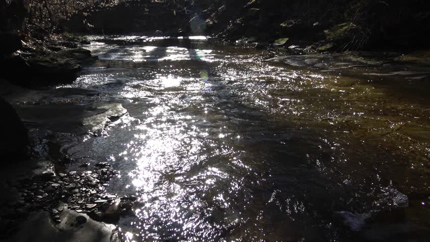 Flowing water, reflection, background. A small river, originating from a waterfall. Blue Hen Falls, Cuyahoga Valley National Park. Ohio USA