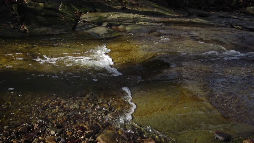 Flowing water, reflection, background. A small river, originating from a waterfall. Blue Hen Falls, Cuyahoga Valley National Park. Ohio USA