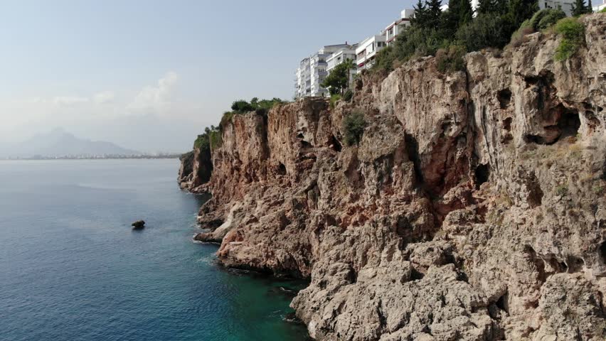 Colorful Antalya city panorama aerial seaside view. Rocks Hill Beach and Sea transparent water