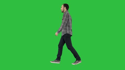Young casual man walking on a Green Screen, Chroma Key.