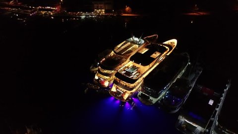 Luxury yachts in harbor in Mediterranean country, Europe, aerial night view. People have a great fun during boat party.  Concept: yacht show, yacht week, or yacht festival in France, Monaco, Italy
