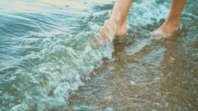 A young woman walks through the water. Brunette enjoying the rays of the sun. Woman posing on camera. Atmospheric video. Vacation on the beach of the ocean. Freedom. Independent woman