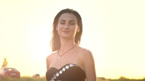 Young woman in a swimsuit running through the grass. Brunette enjoying the sunset rays. Dance with the wind. Woman posing on camera. Atmospheric video. Vacations in nature. Freedom. Independent woman