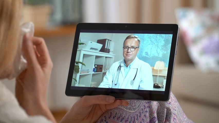 Medicine online. Young woman consults with her doctor using video chat at home. The doctor prescribing her a nosal medicine for a cold. | Shutterstock HD Video #1020526861