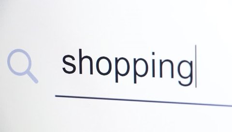 The keyword "shopping" is being typed in a search bar on a computer LCD monitor screen, selective focus