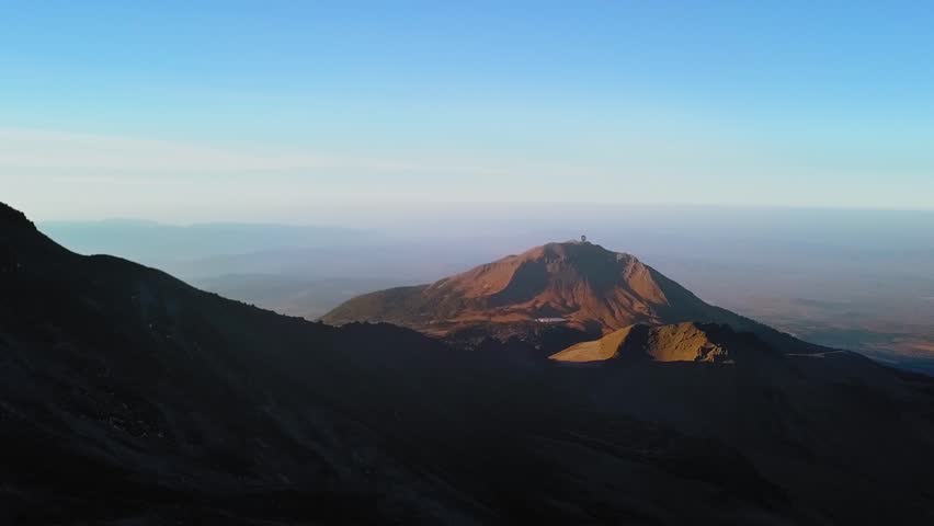 Aerial of the beautiful pico de orizaba volcano with a view of the Large Millimeter Telescope in Mexico at sunrise