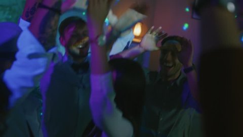 At the House Party: Diverse Group of Friends Have Fun, Dance, Jump, Socialize. Stylish Young People Clubbing. Disco Neon Lights. In Slow Motion.