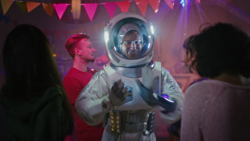 At the College House Costume Party: Fun Guy Wearing Space Suit Dances Off, Doing Robot Dance Modern Moves. With Him Beautiful Girls and Boys Dancing in Neon Lights. Royalty-Free Stock Footage #1020543022