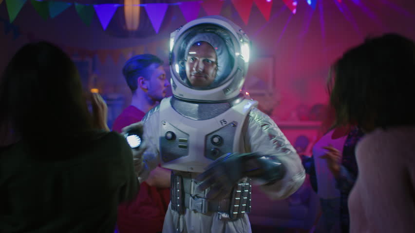 At the College House Costume Party: Fun Guy Wearing Space Suit Dances Off, Doing Robot Dance Modern Moves. With Him Beautiful Girls and Boys Dancing in Neon Lights. Royalty-Free Stock Footage #1020543022