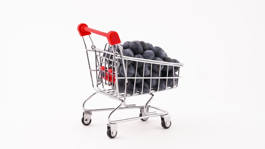 Supermarket trolley with fresh blueberries pile rotating on the turntable. 