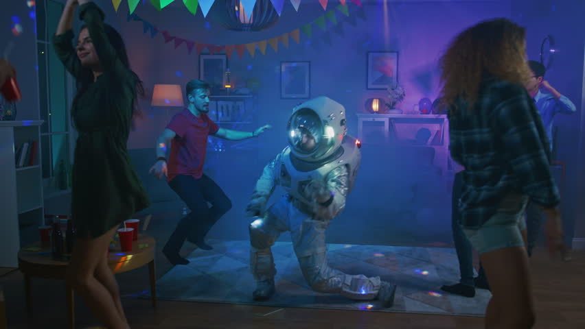 At the College House Costume Party: Fun Guy Wearing Space Suit Dances Off, Doing Groovy Funky Robot Dance Modern Moves. With Him Beautiful Girls and Boys Dancing in Neon Lights. Royalty-Free Stock Footage #1020544114