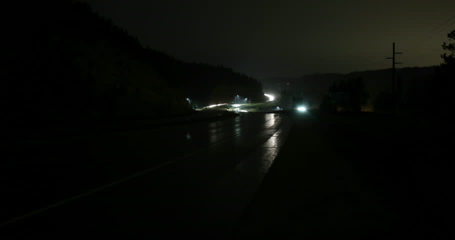 Dark winding wet freeway traffic through a mountain pass outside of Morrison, Colorado at night - 4K time lapse