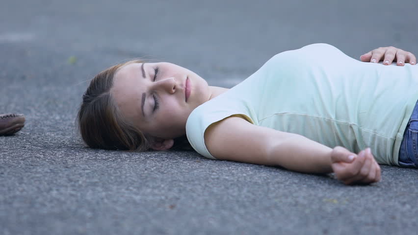 Ambulance crew helping to female victim of accident, putting her on stretcher