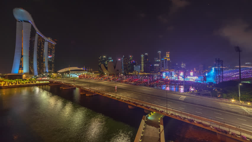 Aerial Time lapse of Singapore city skyline by a river at night during fireworks display during the national day parade preview. Prores 4K.