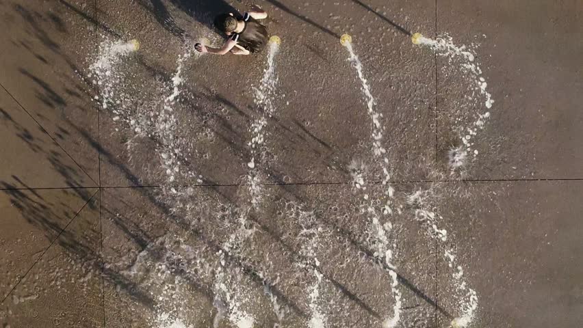 Young Boy Playing at a Splash Pad Rising Aerial View