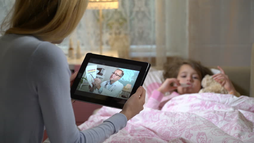 Medicine online. Home quarantine coronavirus. Mom with a little sick daughter gets a doctor's advice using video chat at home. The doctor showing her the results of medical tests | Shutterstock HD Video #1020553675