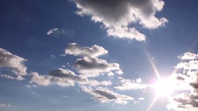 Clear blue sky, time lapse white clouds, beautiful summer sunny day, rolling cloudscape in horizon, real sunny shine, fast moving away, colourful footage.