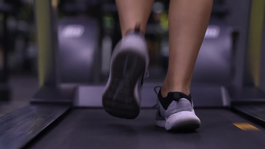 Back view of female legs walking and running on treadmill gym, motivated woman training | Shutterstock HD Video #1020568294