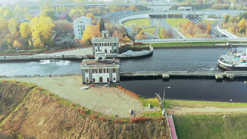 Sluice Gates on the River. Aerial view barge, ship in the river gateway. The movement of ships and barges along the canal through the river gateway in autumn sunny day.