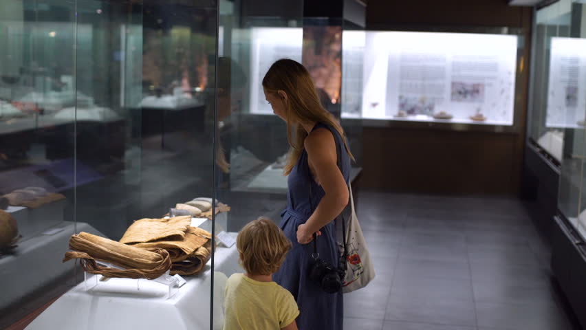 Mother and son watch historical exposition in natural history museum