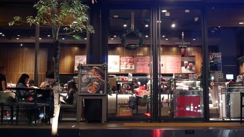 Taipei, Taiwan - November 01, 2018 : Motion of people enjoying coffee inside Starbucks coffee at night with 4k resolution.
