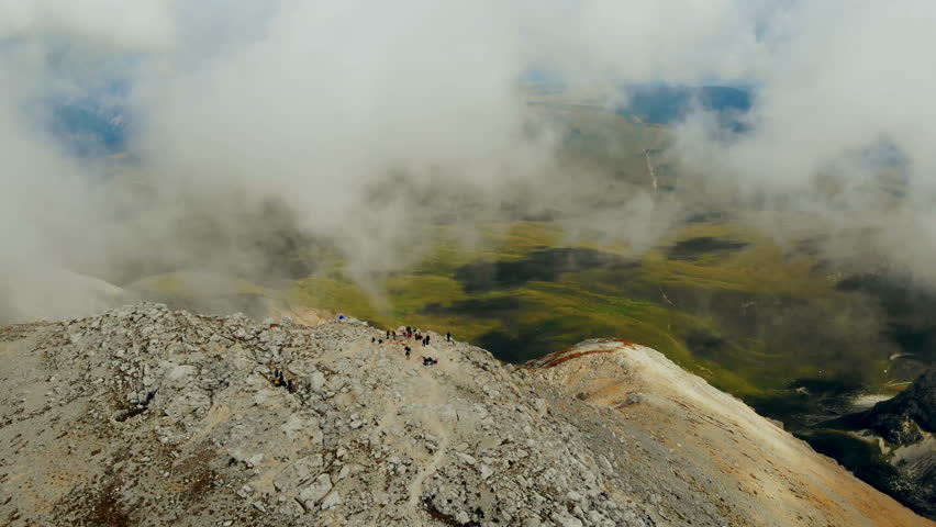 Beautiful aerial shot of cloud topped mountains in the alps. 4k drone aerial shot.