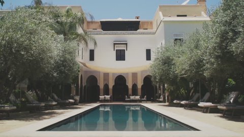 Marrakech, Morocco July 2018. Luxury Hotel Villa des Orangers on a hot sunny day in the center of Marrakech near to 
The Koutoubia Mosque in super slow motion. Beautiful swimming pool to relax. 