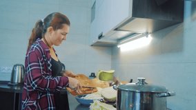 woman in the kitchen preparing a meal concept. girl in the kitchen cuts cabbage with a knife. cook vegetarian lifestyle food healthy food. girl at home in the kitchen slow motion video
