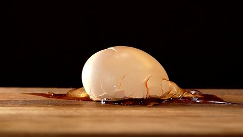 The egg fell and broke. A broken egg is picked up and raised.