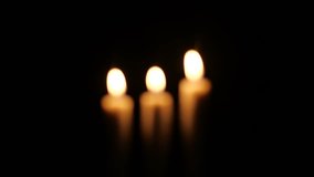 Footage of closeup of candle on black background. Christmas