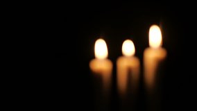 Footage of closeup of candle on black background. Christmas