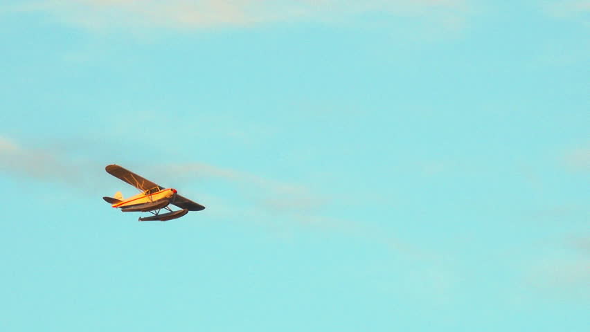 Float plane with no markings flying overhead with golden hour sunset light